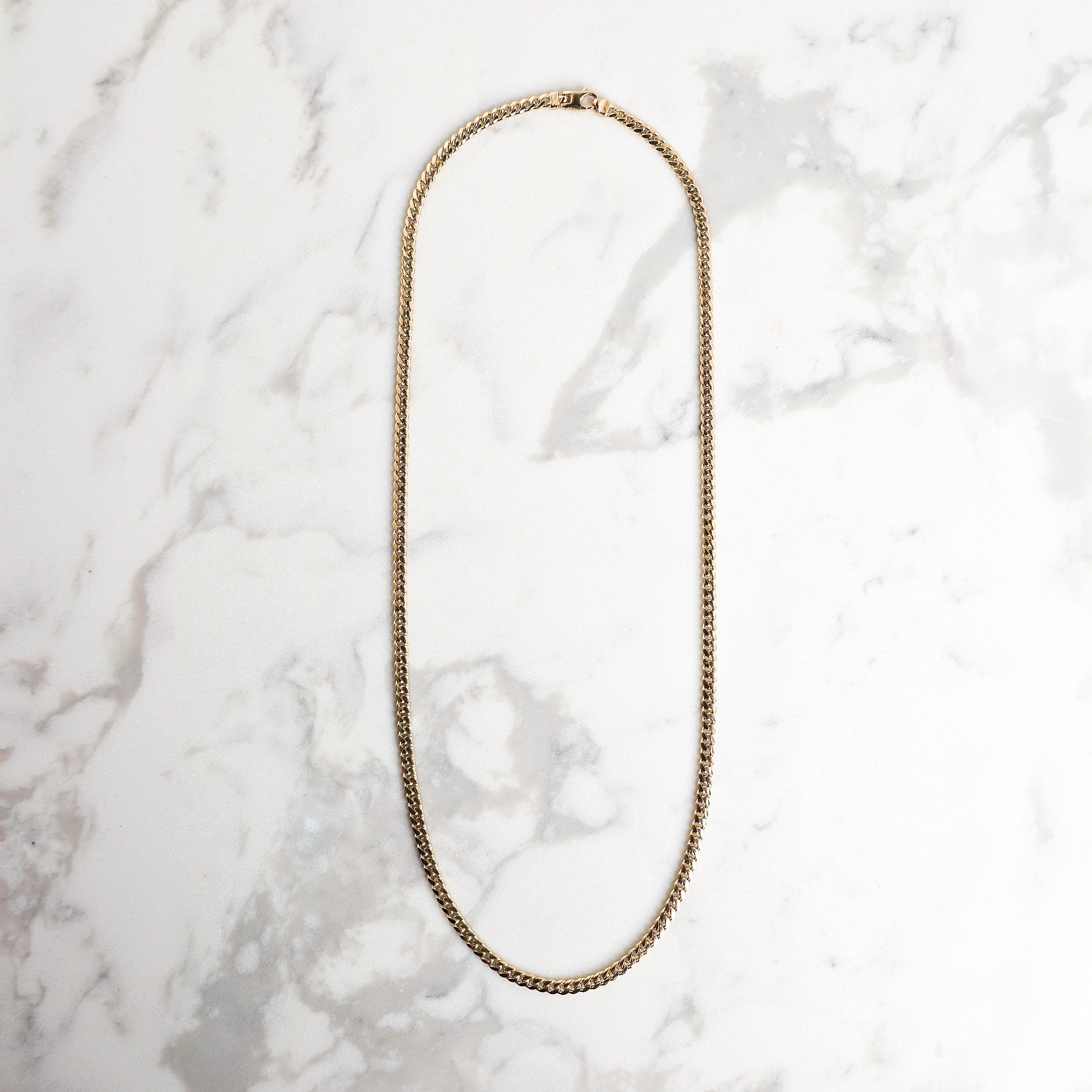 yellow gold mens chain on marble background