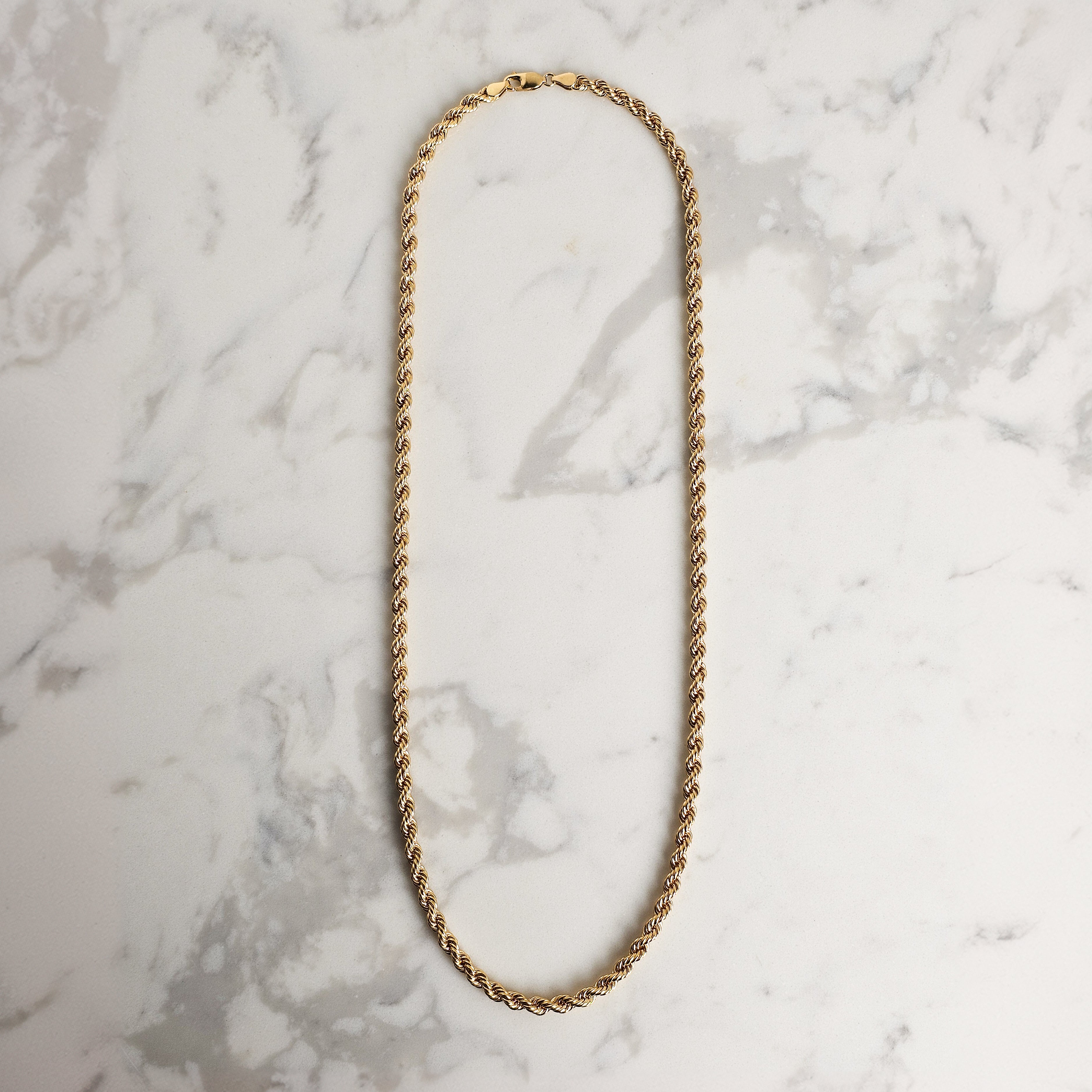 mens rope chain yellow gold marble background