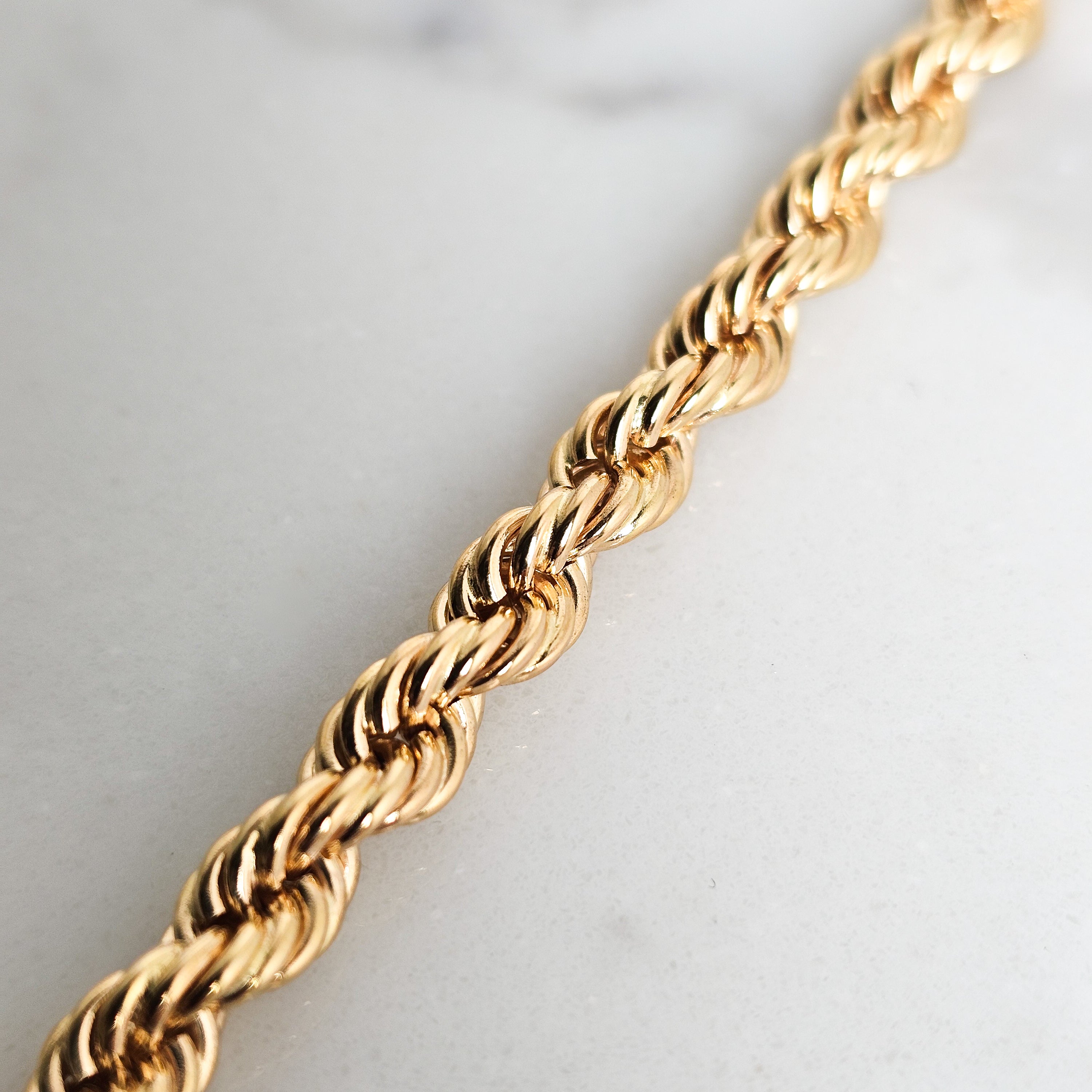 close up detail of yellow gold rope chain in solid gold