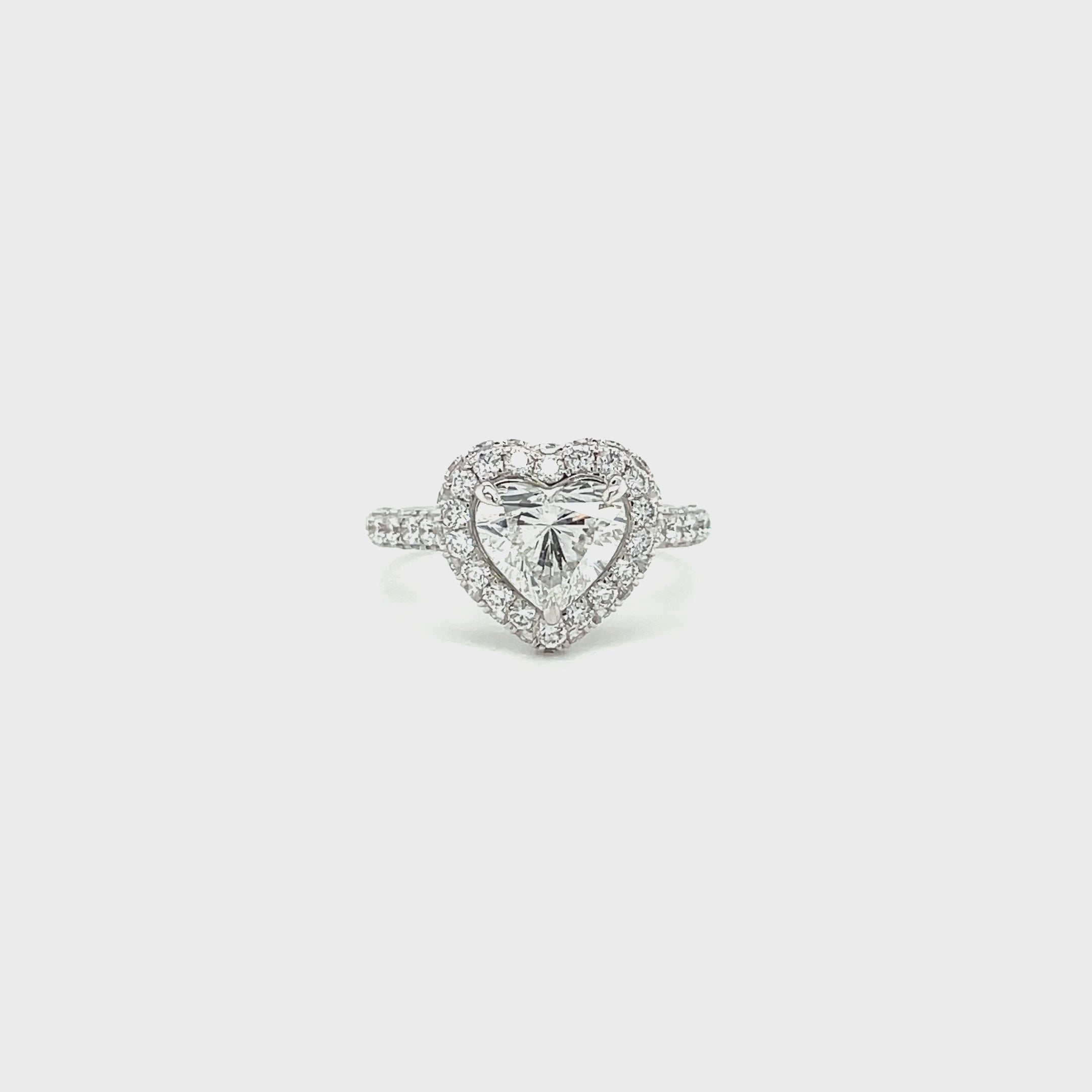 Heart diamond engagement ring on white background spinning slowly