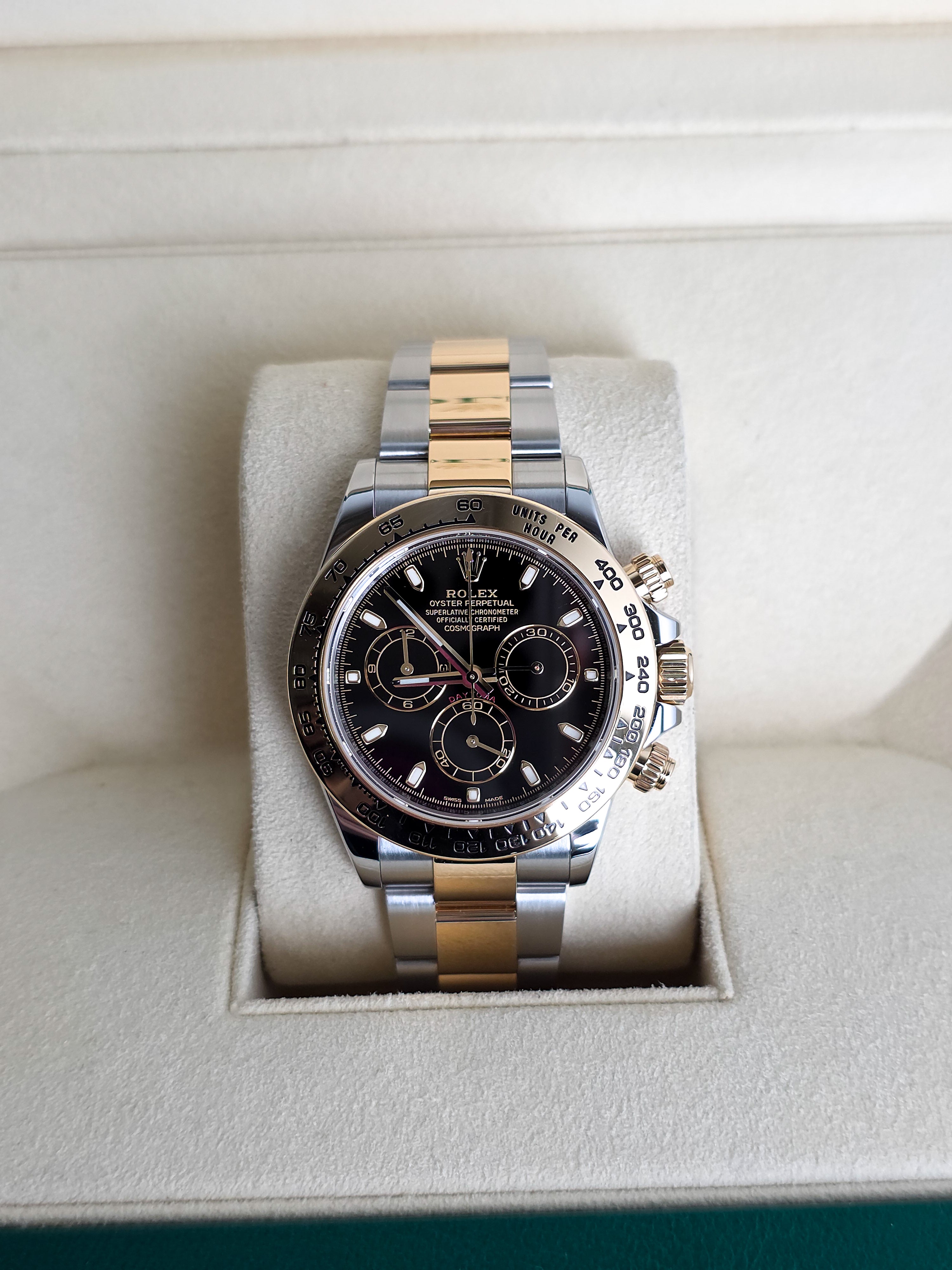 Luxury watch with black dial and gold accents in a white box