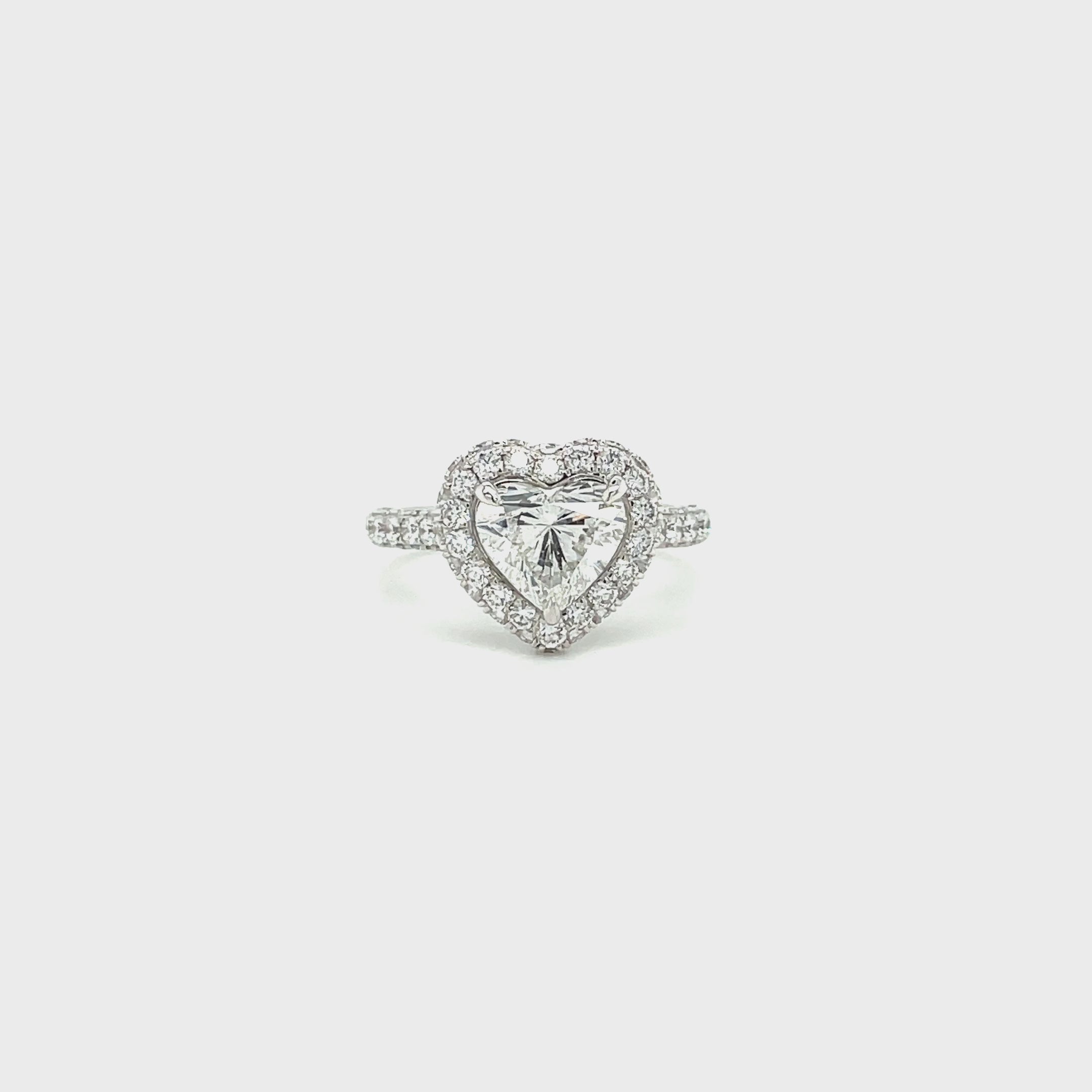 Heart diamond engagement ring on white background spinning slowly 